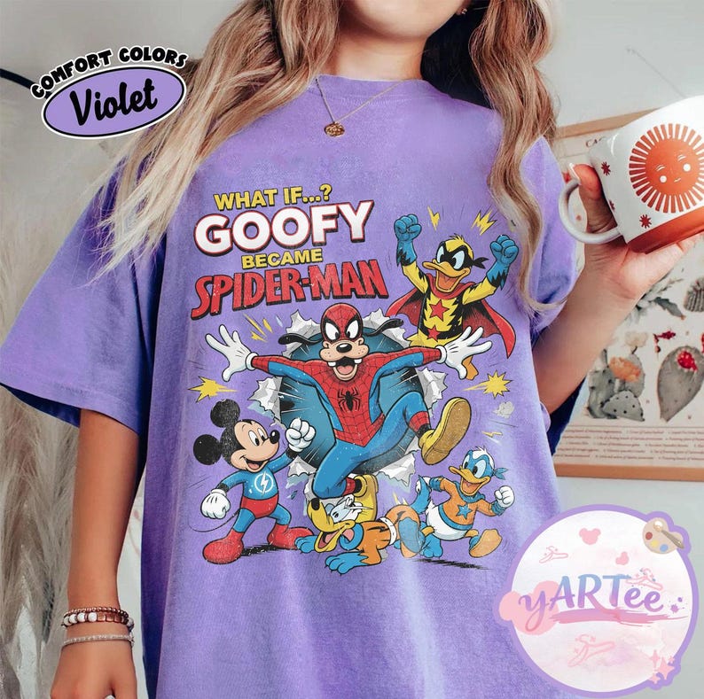 May include: A lilac-coloured t-shirt with a graphic of Goofy as Spider-Man and other Disney characters. The text "WHAT IF...? GOOFY BECAME SPIDER-MAN" is printed above the characters. The shirt has a vintage, distressed appearance.