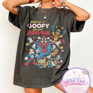 May include: Dark grey t-shirt with a graphic of Goofy as Spider-Man and other cartoon characters. Text reads "WHAT IF...? GOOFY BECAME SPIDER-MAN". The shirt has a vintage, distressed appearance.