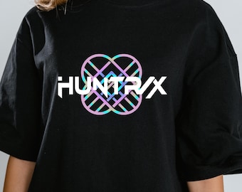 May include: Black t-shirt with the white text "HUNTR/X" and a multi-coloured geometric design above it. The design uses pink, blue, and purple. The shirt has short sleeves and a round neck.