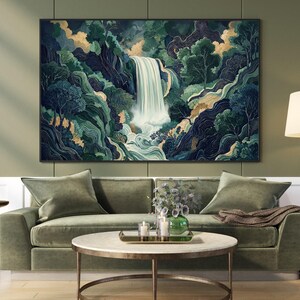 Vertical Japanese waterfall wall art print hanging above a sage green sofa in a modern living room, featuring a cascading white waterfall through deep navy canyon walls and emerald foliage, styled with a round coffee table and neutral decor.