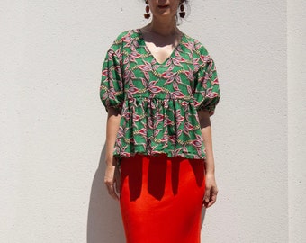 Blusa floral verde em algodão, com mangas bufantes e detalhe peplum.