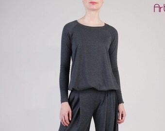 May include: A charcoal gray long-sleeved shirt with a round neckline and raglan sleeves. The shirt is made of a soft, comfortable fabric and has a relaxed fit.