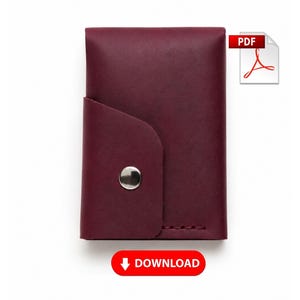 Pode incluir: Um porta-cartões de couro bordô profundo com uma aba frontal curva fixada por um botão de pressão de metal prateado. O item inclui um ícone de PDF no canto superior direito e um botão vermelho na parte inferior com o texto DOWNLOAD.