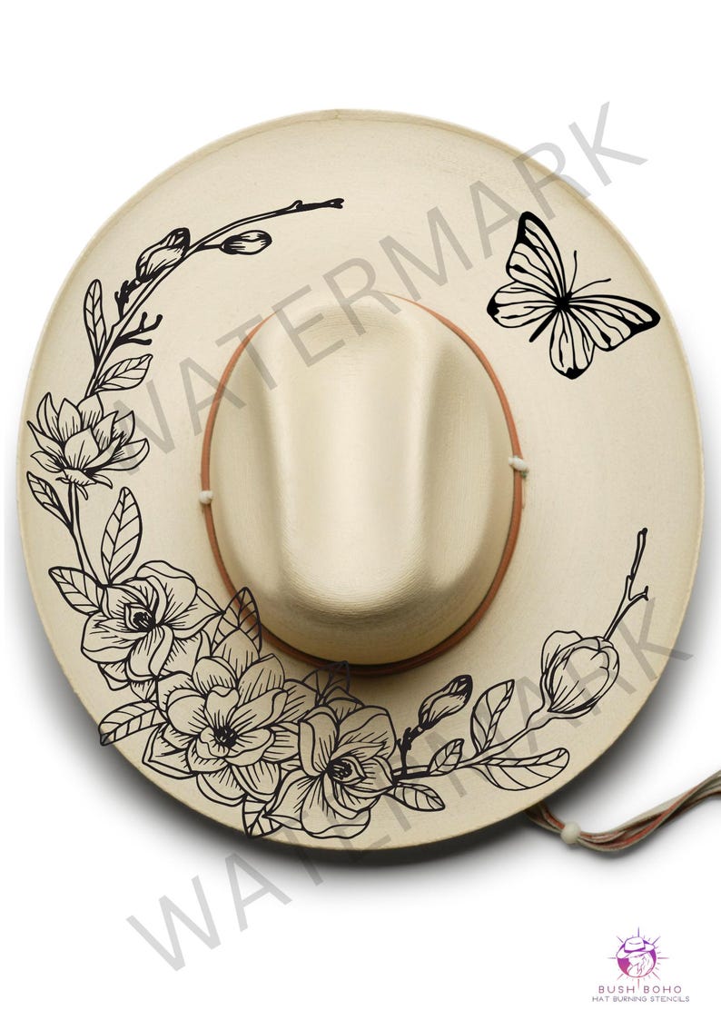 K&ouml;nnte beinhalten: Ein beiger Cowboyhut mit einem schwarzen Blumendesign und einem Schmetterling an der Seite. Das Design umfasst Magnolienbl&uuml;ten und Bl&auml;tter.