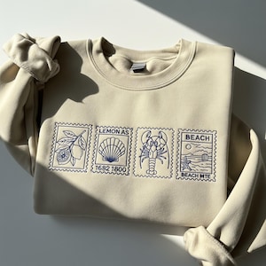 Felpa con ricamo di conchiglie, girocollo ricamato con cartolina estiva, ricamo costiero Dolce Vita, regalo per gli amanti dell'oceano costiero