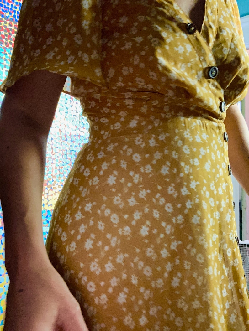 2010s does 1930s tumeric color all polyester chiffon dress with decorative front buttons, back zipper closure.