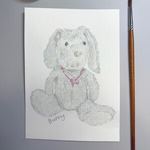 May include: Watercolor painting of a gray bunny with long ears and a pink ribbon around its neck. The word "Bunny" is written in cursive at the bottom. The bunny is sitting on a white background.