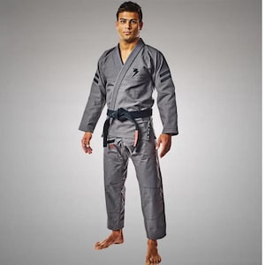 May include: A gray Jiu-Jitsu gi with black piping and a black belt. The gi has a lightning bolt logo on the chest and three black stripes on each sleeve.