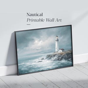 Puede incluir: Una impresión de arte mural enmarcada que presenta una pintura de un faro blanco sobre un acantilado rocoso con vistas a un océano azul grisáceo turbulento y tormentoso con olas rompientes bajo un cielo nublado. El texto "Nautical Printable Wall Art" es visible arriba.