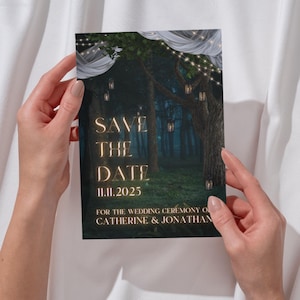 May include: Save the Date wedding invitation with a dark green forest background, glowing lights, and white fabric draped over the trees. The text reads "Save the Date" in gold lettering with the date "11.11.2025" below. The names "Catherine & Jonathan" are at the bottom of the invitation.