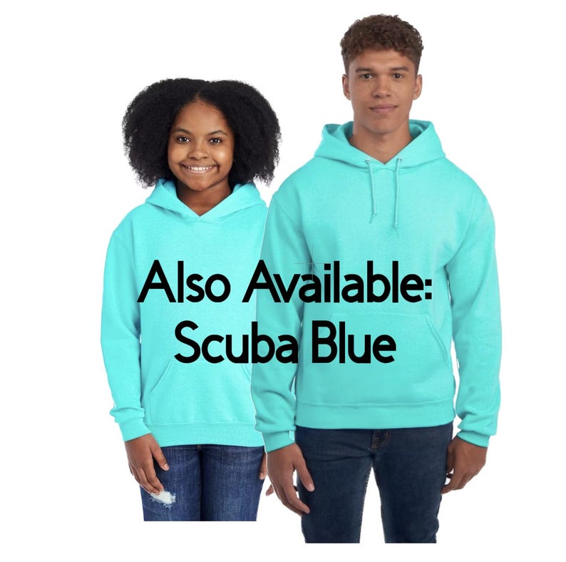 May include: Two people wearing matching Scuba Blue hoodies with front pockets and drawstrings. The text "Also Available: Scuba Blue" is printed on the front of the hoodies. The hoodies are paired with blue jeans.
