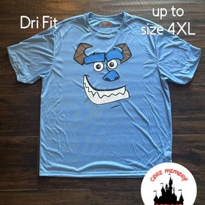 May include: A light blue Dri Fit t-shirt with a graphic of Sulley from Monsters Inc. The shirt is available in sizes up to 4XL. The shirt is made by Core Memory Designs.