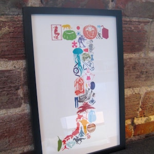 May include: A framed print of a colorful illustration of a letter 'I' made up of various images, including a pumpkin, a star, a jellyfish, a jukebox, a tree, and a planet.