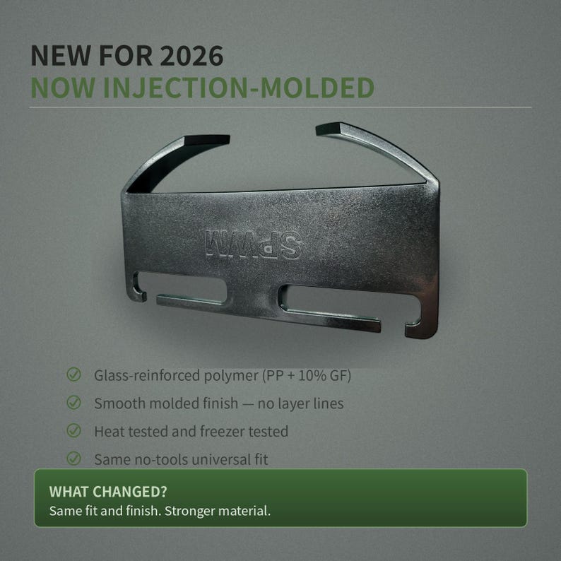 May include: A dark gray injection-molded clip with a smooth finish and the text "SPWM" embossed on the front. The clip features a curved top section and two rectangular slots at the bottom. Text on the image reads "NEW FOR 2026 NOW INJECTION-MOLDED" and "WHAT CHANGED? Same fit and finish. Stronger material."