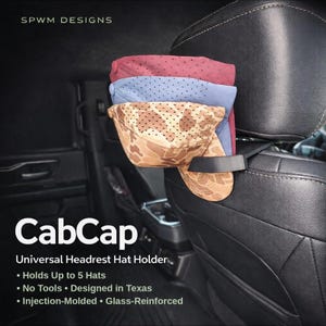 May include: A black plastic CabCap universal headrest hat holder attached to a vehicle seat headrest. The holder supports three stacked baseball caps in maroon, blue, and tan camouflage patterns. Text on the image includes SPWM DESIGNS, CabCap, and Universal Headrest Hat Holder, noting it holds up to 5 hats, requires no tools, is designed in Texas, and is injection-molded and glass-reinforced.