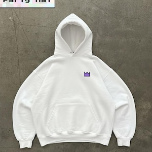 May include: White hooded sweatshirt with a front pocket and a purple crown graphic. The text "Party Hat" is displayed in a pixelated font at the top. The sweatshirt is made of a soft material.