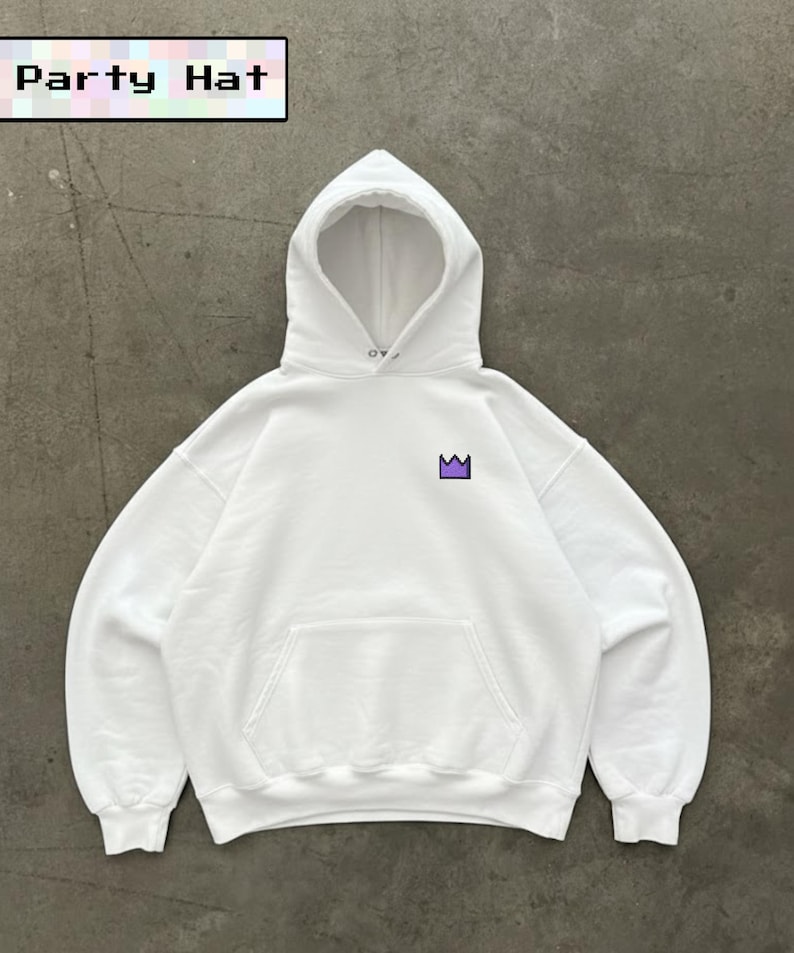 May include: White hooded sweatshirt with a front pocket and a purple crown graphic. The text "Party Hat" is displayed in a pixelated font at the top. The sweatshirt is made of a soft material.