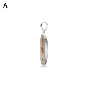 May include: A silver pendant featuring an oval-shaped stone with a cream-colored base and dark brown dendritic inclusions. The pendant has a polished silver metal frame and a small silver bail at the top for attachment to a necklace chain.