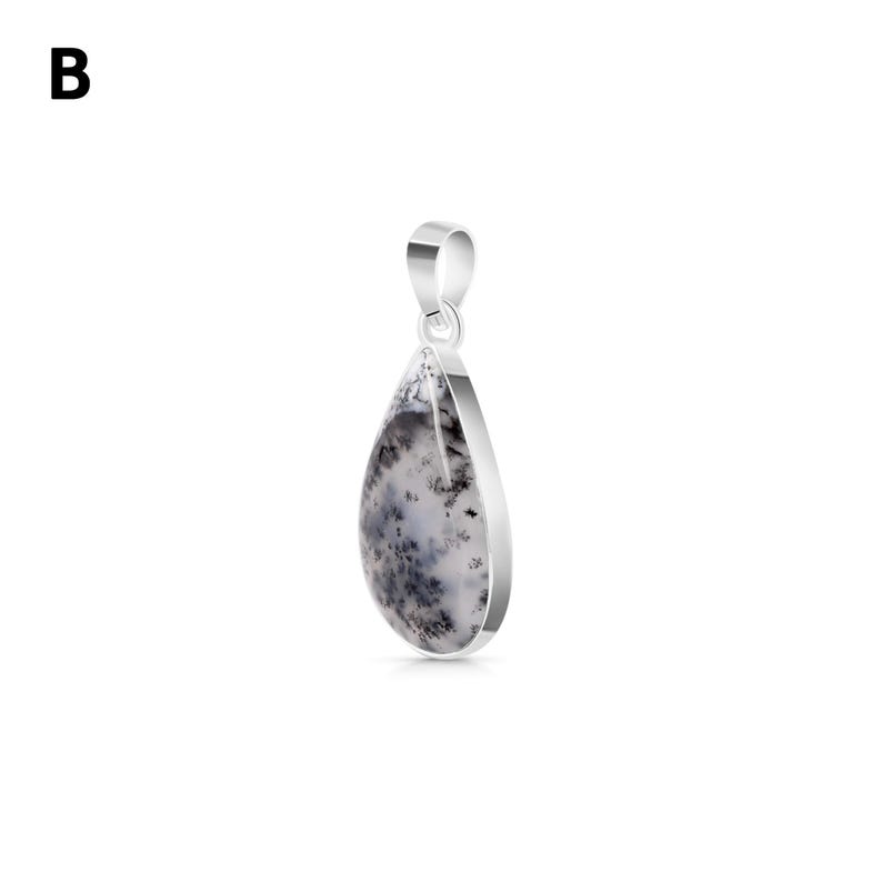 May include: A teardrop-shaped pendant featuring a white stone with black dendritic inclusions, set in a polished silver-toned metal frame with a matching silver-toned bail at the top. The letter B is visible in the upper left corner of the image.