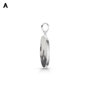 Puede incluir: Un colgante de plata con una piedra ovalada de base blanca e inclusiones dendr&iacute;ticas oscuras en forma de &aacute;rbol. La piedra est&aacute; engastada en un marco de plata pulida lisa con una anilla de plata a juego en la parte superior para la cadena.