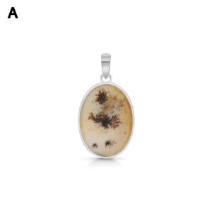 May include: An oval pendant featuring a smooth, cream-colored stone with dark brown, fern-like dendritic inclusions. The stone is encased in a polished silver-toned metal bezel setting with a matching silver-toned bail at the top for suspension.