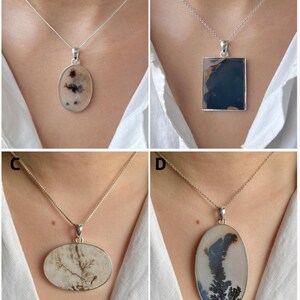 May include: Four silver necklaces featuring distinct pendants: A is an oval stone with dark inclusions, B is a rectangular dark blue stone, C is a horizontal oval stone with brown dendritic patterns, and D is a large vertical oval dendritic stone.