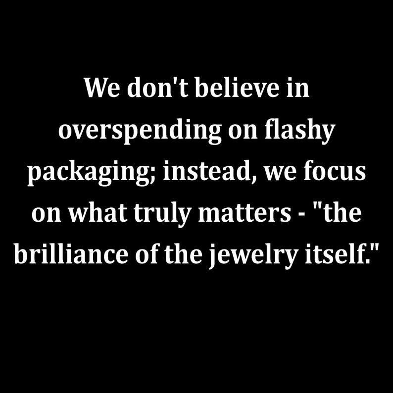 以下が含まれることがあります： 黒い背景に白い文字で次のように書かれています：We don't believe in overspending on flashy packaging; instead, we focus on what truly matters - "the brilliance of the jewelry itself." テキストは中央揃えで、セリフフォントで書かれています。