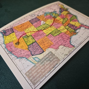 May include: A map of the United States with a red thread linking two locations. A small heart charm is attached to the thread. A paper airplane is at the end of the thread. Text on the image reads: "We are connected by a red thread..."