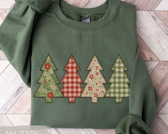 May include: Military green sweatshirt with four Christmas tree appliqués. The trees feature floral and plaid patterns in red, green, and white. The sweatshirt has a crew neck and long sleeves.