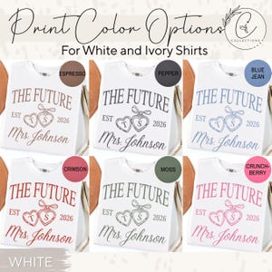May include: White t-shirts with various print color options. Each shirt features the text "THE FUTURE EST 2026 Mrs. Johnson" with heart-shaped designs. Print colors include espresso, pepper, blue jean, crimson, moss, and crunch-berry.