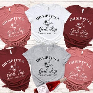 May include: Six different coloured t-shirts with the text "Oh Sip It's A Girls Trip Napa Valley 2025" and a graphic of a wine bottle, wine glass, and corkscrew.