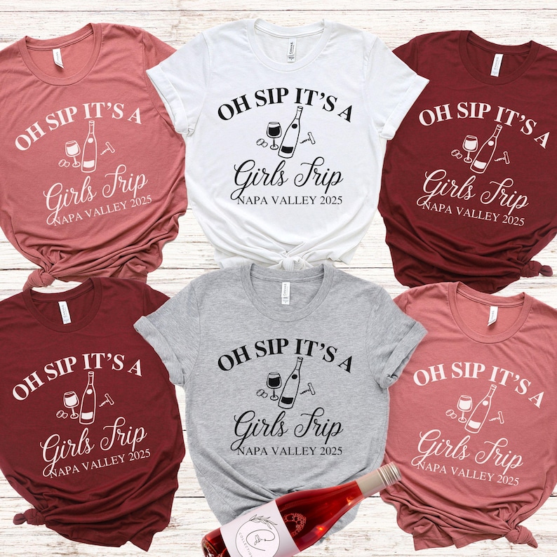 May include: Six different coloured t-shirts with the text "Oh Sip It's A Girls Trip Napa Valley 2025" and a graphic of a wine bottle, wine glass, and corkscrew.