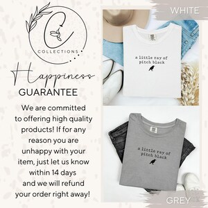 May include: White and grey t-shirts with the text "a little ray of pitch black" and a small bird graphic. The image also includes the text "Happiness Guarantee" and the brand logo.
