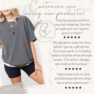 May include: A gray t-shirt with the text "a little ray of pitch black" and a small bird graphic. The shirt is part of the "Pepper" collection and is shown with customer reviews.