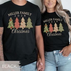 May include: Black t-shirts featuring the text MILLER FAMILY 2026 and Christmas in a cream font. The design includes four stylized Christmas trees with varied patterns in green, red, and beige, including floral, plaid, and gingham prints.