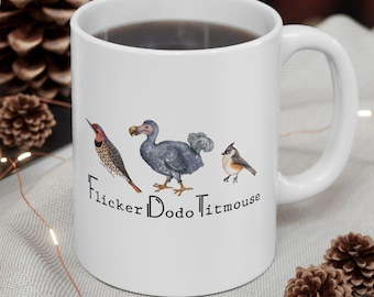 May include: White ceramic coffee mug with a black outline of a dodo, a flicker bird, and a titmouse. The text "Flicker Dodo Titmouse" is printed below the birds.