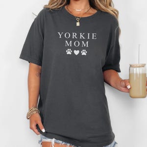 May include: A dark gray t-shirt with the text "Yorkie Mom" and two paw prints and a heart in white.