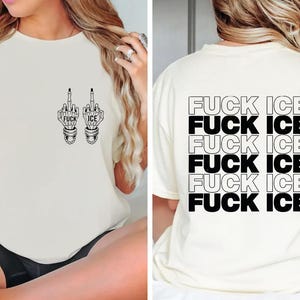 Pode incluir: Camiseta creme com texto gr&aacute;fico e ilustra&ccedil;&otilde;es em preto. A frente apresenta dois dedos do meio com as palavras "FUCK ICE". A parte de tr&aacute;s da camisa repete "FUCK ICE" em um design empilhado.