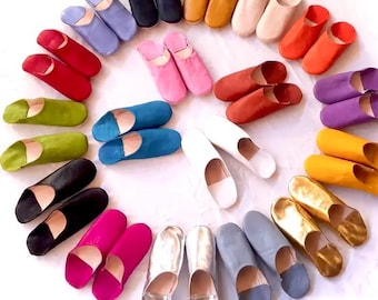 Puede incluir: Una variedad de zapatillas de cuero de colores dispuestas en círculo. Las zapatillas están hechas de cuero suave y tienen un ajuste cómodo. Son perfectas para relajarse en casa o para usar como zapatos de interior.