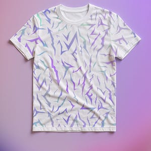 May include: White t-shirt featuring a repeating design of jagged, lightning bolt-like shapes in purple and teal hues. The short-sleeved shirt is shown against a gradient purple backdrop.