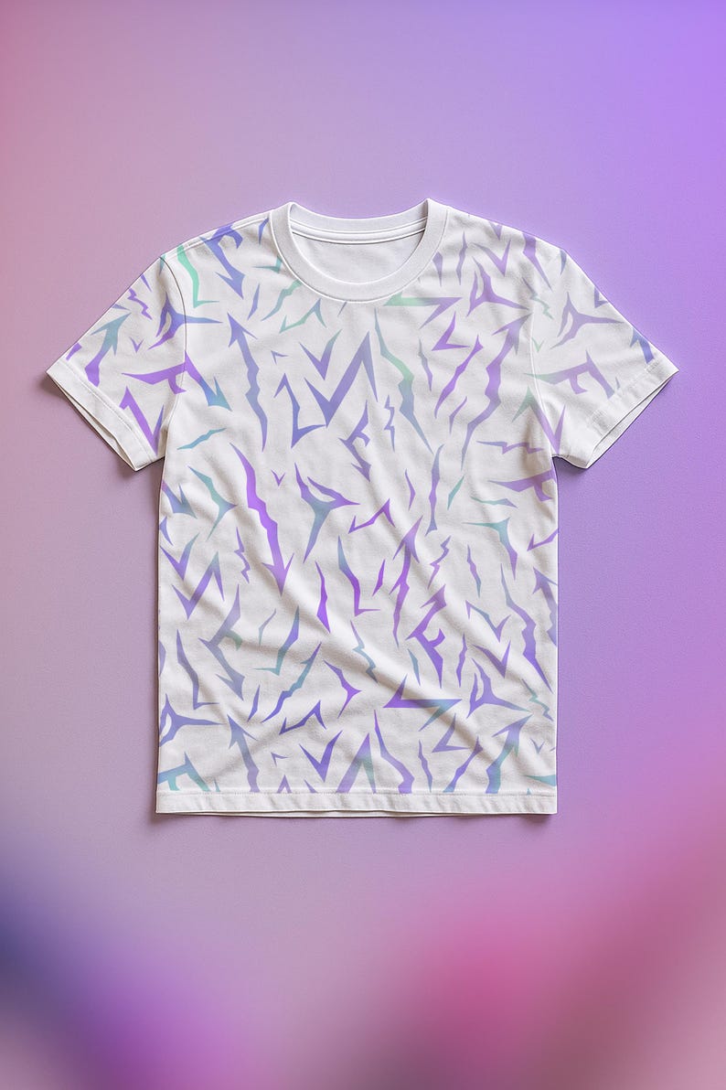 May include: White t-shirt featuring a repeating design of jagged, lightning bolt-like shapes in purple and teal hues. The short-sleeved shirt is shown against a gradient purple backdrop.
