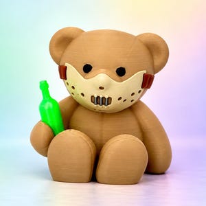 Puede incluir: Una figura de oso de peluche marrón impresa en 3D que lleva una máscara facial beige con detalles laterales de color rojo oscuro y una rejilla metálica. El oso tiene ojos negros y sostiene una pequeña botella de color verde neón.