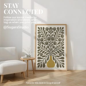 May include: A framed art print featuring a floral design in olive green and mustard yellow. The artwork is displayed in a living room setting with a white chair and small side table. Text on the image reads "STAY CONNECTED".