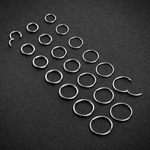 May include: A collection of 20 silver-toned hoop earrings of various sizes, arranged in a pyramid shape on a black background.