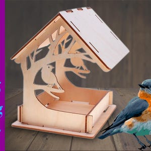 May include: A wooden bird feeder with a roof and a tray for birdseed. The feeder has a cutout design of a tree with birds on the branches. A bluebird is perched on the edge of the feeder.