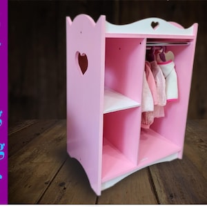 May include: A pink wooden doll wardrobe with a white top and shelves. The wardrobe has a heart-shaped cutout and a clothes rod with hanging doll clothes. The image also includes the text "svg, dxf, eps, png, jpeg, pdf" in blue.