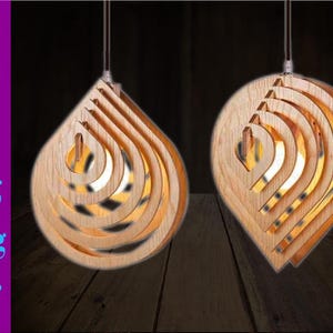 May include: Two wooden pendant lights in a teardrop shape with layered, concentric circles. The lights are hanging against a dark background.
