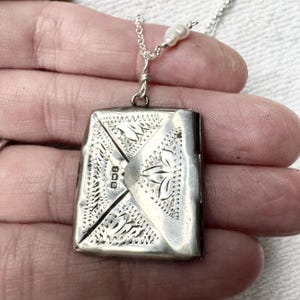 A 1912 Birmingham hallmarked envelope stamp holder etched with forget me not and leaf designs, containing Victorian stamp & tiny drawing