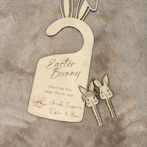 May include: Wooden Easter bunny door hanger with bunny ears and the text "Easter Bunny" and "Please use this magic key to visit Jacob, Caspar, Ezra & Kea". Two wooden bunny keychains are included.