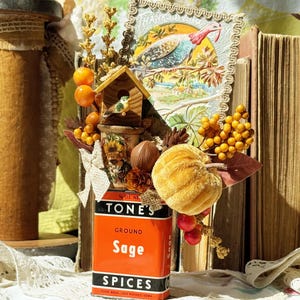 Lata de tempero vintage "Sage" decorada com um antigo cartão postal de Ação de Graças, abóbora de veludo, itens vintage, casa para pássaros e folhagens outonais.